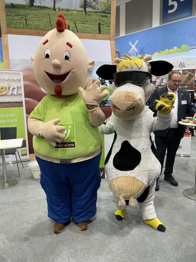 Foto: mein-ei.nrw-Maskottchen "Kei" und "Lotte", Maskottchen der Landesvereinigung der Milchwirtschaft NRW auf der Grünen Woche 2023 (Copyright: Jörg Meyer | jumpr.com)