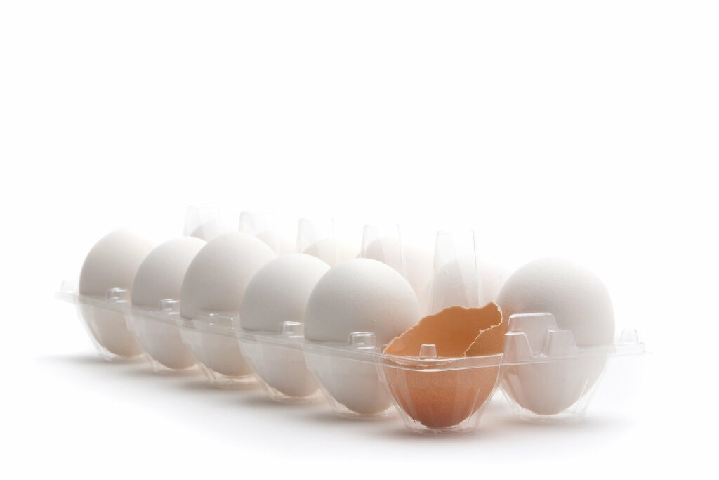 Foto: weiße Eier und eine halbe braune Eierschale in einer offenen Verpackung (Copyright: ChepeNicoli – pixabay.com)